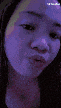 a close up of a woman 's face with a purple background and a caption that says capcut