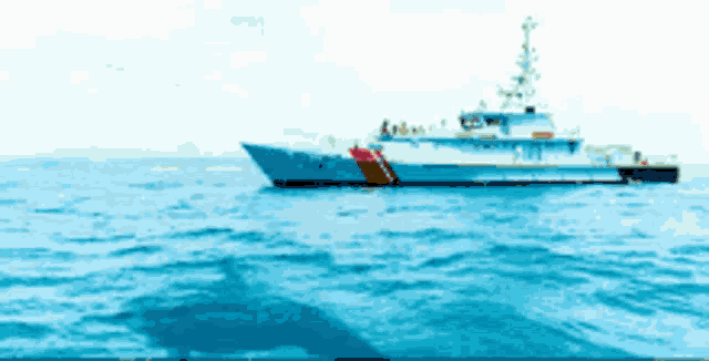 a large blue and white boat with a red stripe on the side
