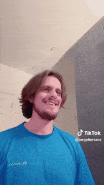 a man wearing a blue columbia t-shirt is smiling in front of a mirror