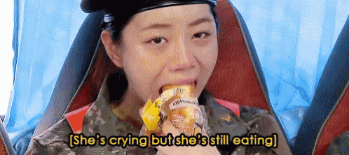 a woman in a military uniform is crying while eating food .
