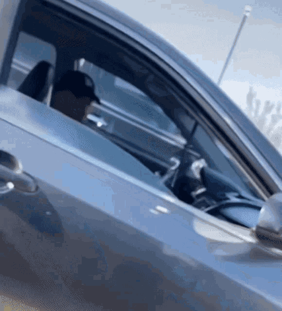 a man wearing a baseball cap is driving a car .