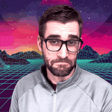 a man with glasses and a beard is standing in front of a colorful background