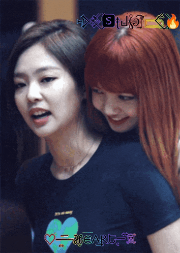 a girl with red hair is hugging another girl who is wearing a shirt that says heart