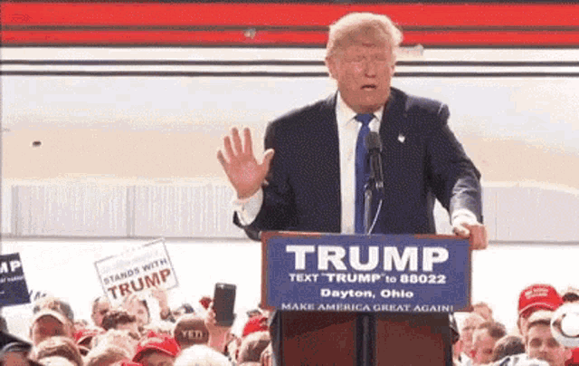 donald trump is giving a speech at a podium that says trump on it