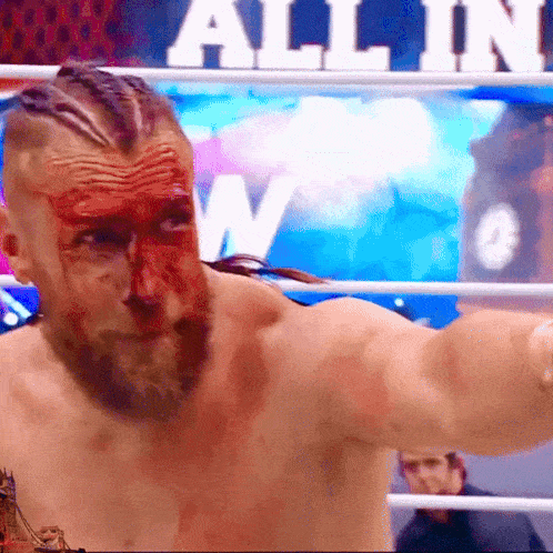 a man with blood on his face is standing in a boxing ring with the word allin in the background