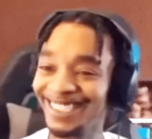 a man wearing headphones is smiling and holding a cell phone .