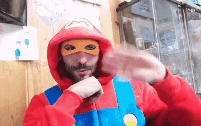 a man in a mario costume is wearing a red hoodie