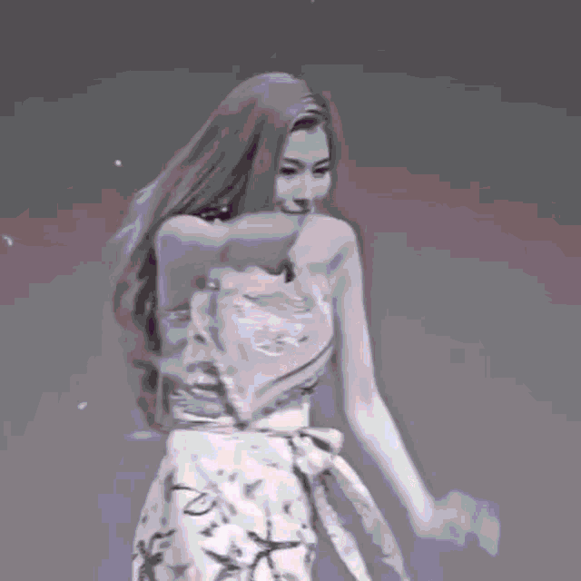 a black and white photo of a woman in a strapless dress dancing .