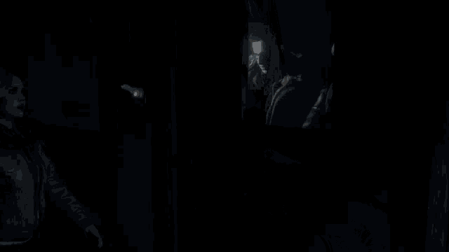 a close up of a woman 's face in a dark room talking to someone .