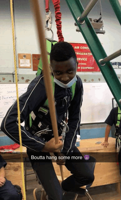 a boy wearing a mask is hanging from a rope in front of a sign that says air conditioning