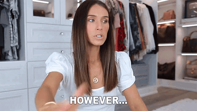 a woman in a white shirt says however in front of a closet full of clothes