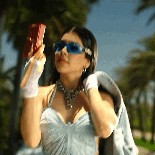 a woman in a blue dress is holding a red box