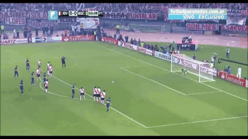 a soccer game is being played in a stadium sponsored by santander and total quartz