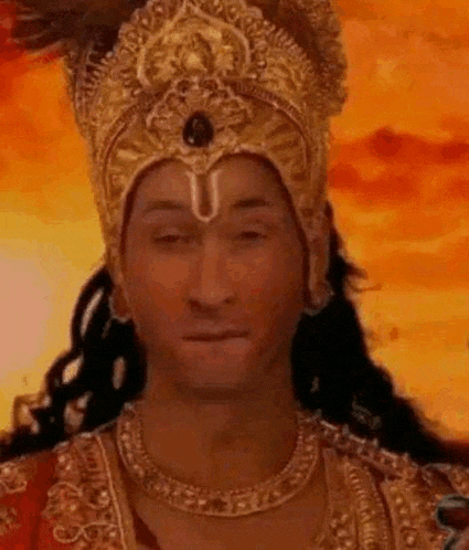 a man is wearing a crown and a necklace and making a face .
