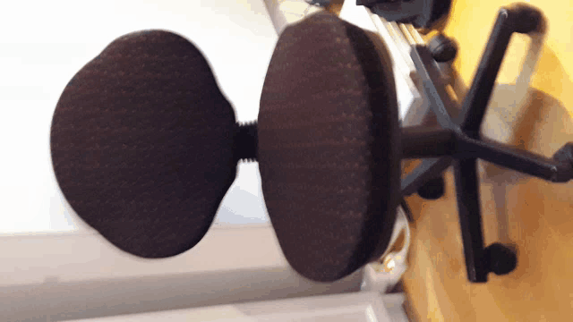 a black office chair is sitting on a wooden surface