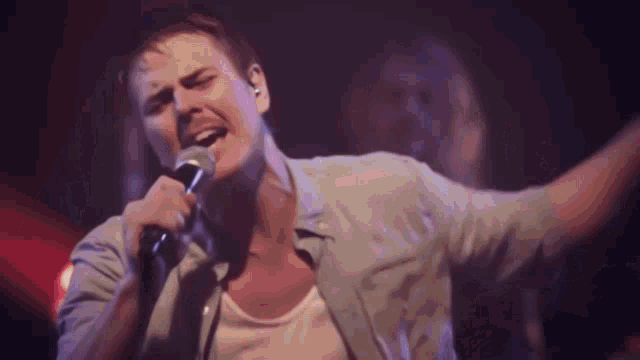 a man singing into a microphone in a dark room