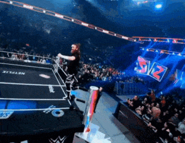 a man in a wrestling ring with a red bull can in front of him