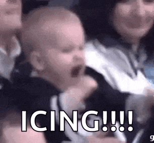 a baby is crying while being held by a woman in a crowd of people .