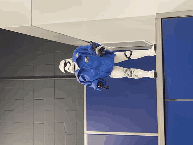 a storm trooper in a blue jacket has a sticker on his chest that says ' gdc '