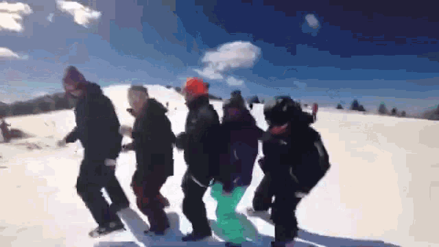 a group of people dancing in the snow on a sunny day
