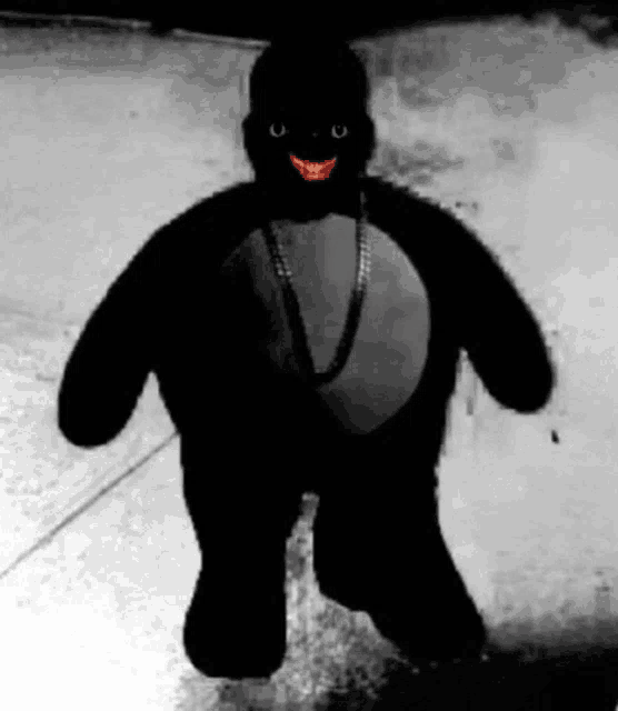 a black and white photo of a stuffed animal wearing a necklace