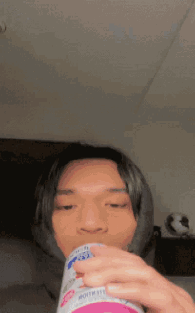 a young man is drinking from a can that says ' motivation ' on the side