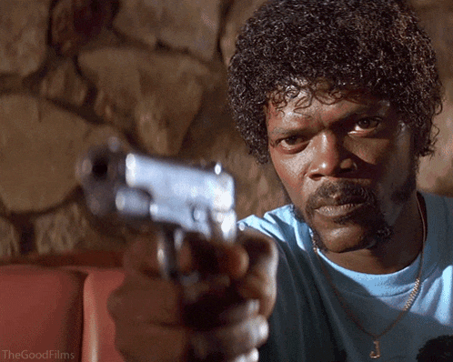 a man in a blue shirt is pointing a gun at the camera with the words " the good films " on the bottom