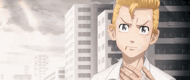 a man in a white shirt is standing in front of a building with his hands on his chest