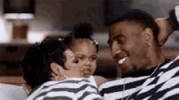 a man and woman are sitting on a couch holding a little girl .