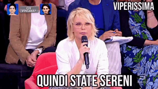 a woman holding a microphone with the words quindi state sereni written below her