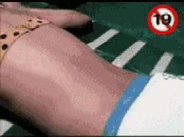 a woman in a bikini is laying on a bed with a sign that says 19 .
