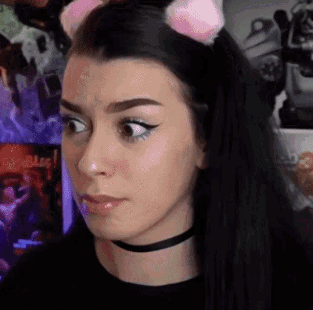 a woman wearing a choker and cat ears is making a face .