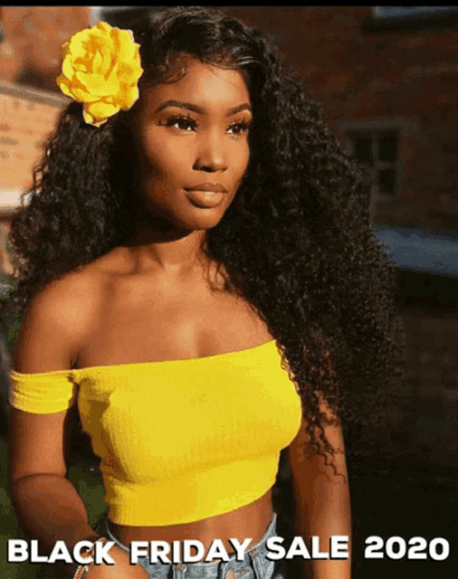 a woman in a yellow crop top with a flower in her hair