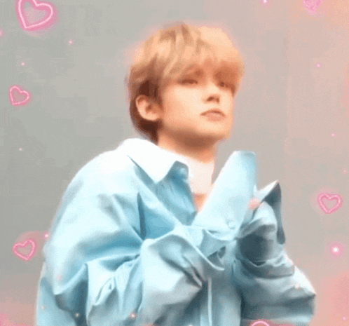a close up of a person wearing a blue shirt with pink hearts surrounding him .