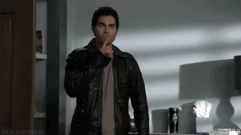 a man in a leather jacket holds his finger to his mouth in front of a sign that says play ) filmes v2