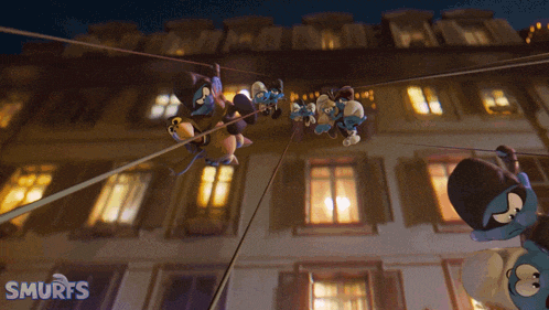 a group of smurfs hanging from a rope in front of a building