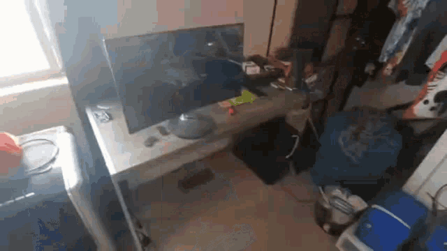 a computer monitor is sitting on top of a messy desk in a room .