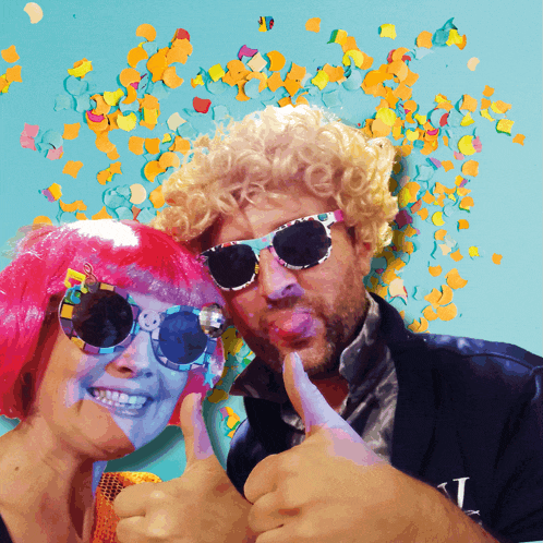 a man wearing sunglasses and a woman wearing pink wigs give a thumbs up