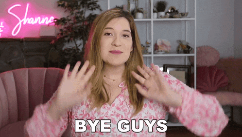 a woman says bye guys in front of a pink chair