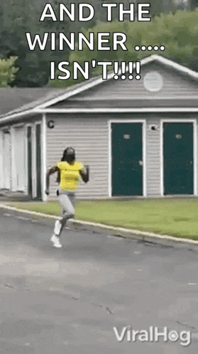 a woman is running down a street in front of a house with the words `` and the winner isn 't '' .