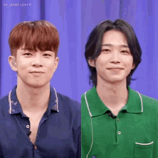 two young men are standing next to each other and smiling .