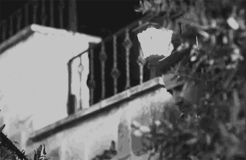 a black and white photo of a balcony with a lamp on it