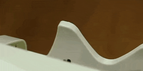 a close up of a white object against a brown wall