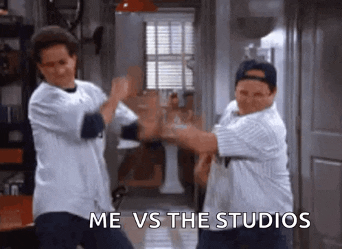 two men are standing next to each other in a hallway with the words `` me vs the studios '' written on the bottom .