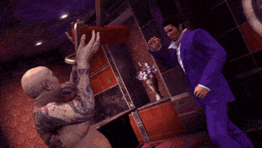 a man with a tattoo on his chest is being kicked by another man in a suit