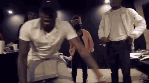 a group of men are dancing in a dark room .