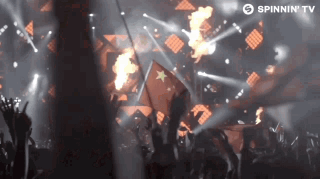 a crowd of people at a concert with a spinnin tv logo on the bottom