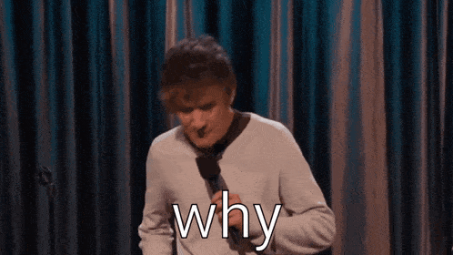 a man is holding a microphone and saying why .