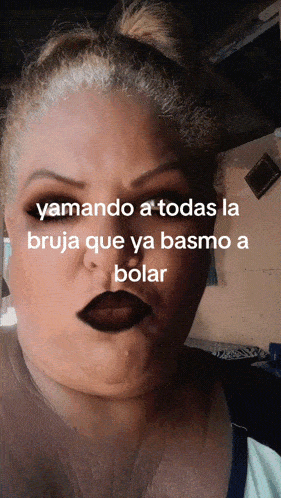 a woman with a bun on her head has black lipstick on her lips