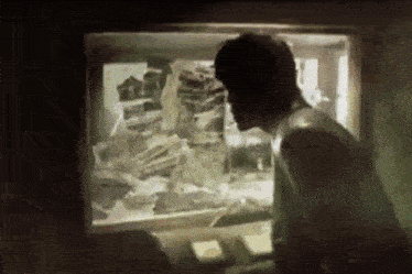 a man is looking out of a window at a display of a skeleton .